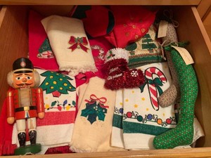 Christmas hand towels, potholders, nut cracker all in drawer