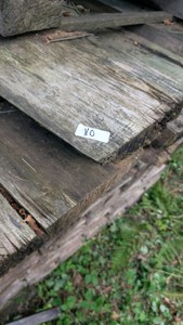 huge pile of dried oak hardwood poles beams post lumber construction lot