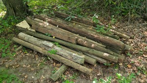 pile of 4-ft treated short posts. construction project fencing, commercial building