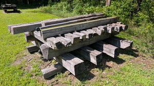 Large pallet stack of dried cured properly aged oak barn, wood posts, beams construction