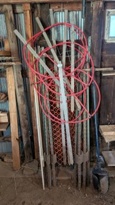 lot of fence posts hoses. yard tools, garage stuff post hole digger to a lot