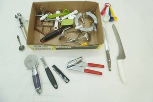 kitchen utensils including pizza cutter, knives, can opener, measuring spoons and more