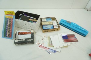 home office supplies including a hole punch, pencils, packing list pouches