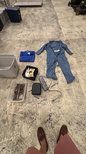 Tote of misc items coveralls, power strip, tools, etc
