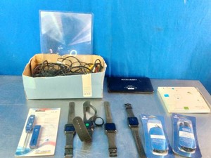 Collection of assorted electronics, tech accessories, and fitness wearables