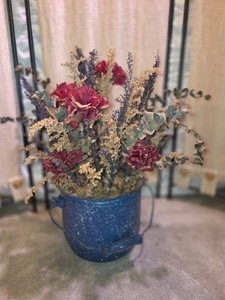 Dried flower arrangement in blue speckled metal pot