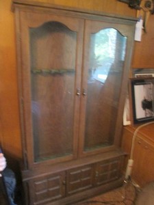 Vintage wood 12-space9 gun cabinet with glass front doors and storage cupboard underneath