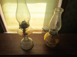 Pair of assorted size antique glass oil lamps with hurricane shades