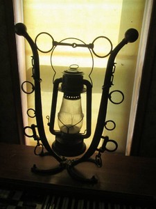 Antique freestanding cast iron horse shoe themed oil lantern and holding base