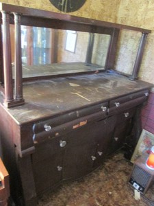Antique dark wood sideboard buffet cabinet with column style covered overhead, mirrored back and glass pulls on the doors and drawers