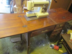 Vintage wood seamstress table with Sears Kenmore sewing machine and bench style seat