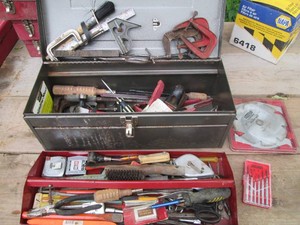 Metal 22in toolbox containing a wide variety of assorted hand tools and clamps