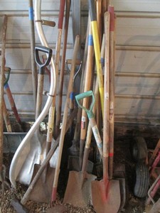 Variety of shovels, post hole diggers, sledgehammer, garden hoe and scythe
