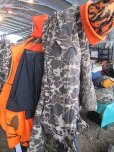 Various Blaze Orange and Camouflage hunting jackets, vests, full suit, hats and black dress slacks