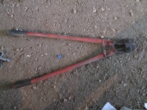Large bolt cutter and pair of large pipe wrenches