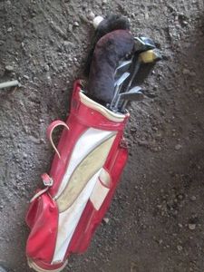 Vintage golf bag with assorted clubs and drivers