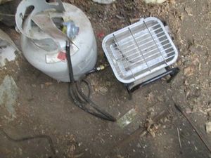 Freestanding propane heater with empty 20lb cylinder and hose