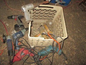 Plastic milk crate with various power tools corded, cordless and pneumatic