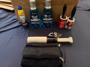 Two Unopened Bottles of Crest Pro Health Mouthwash, Scotch and 3M Lint Rollers, Small Portable Vacuum Cleaner, KLM Toiletry Bag (appears unused) and Coppertone 50 Sunscreen