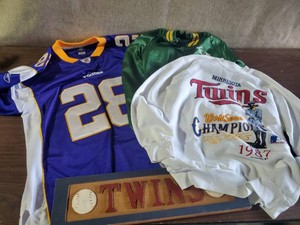 Various Vintage Sports Clothing  Twins, Oakland As Chalkline jacket, Vikings Peterson Jersey, and Twins Wooden Plaque