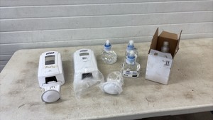Pair of white soap dispensers with drip trays and soap refills