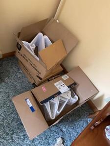 Group of Heavy-Duty White Plastic Clothes Hangers in Open Boxes