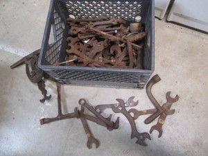 Crate filled with antique wrenches, clamps and more