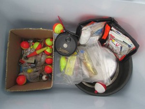 Rubbermaid cooler containing a variety of fishing lures, bobbers and assorted supplies