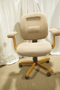 wood frame office chair with tan upholstered armrests, back and seat cushion