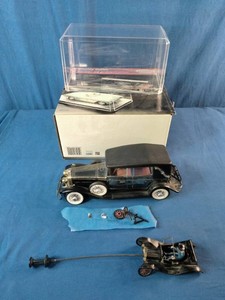 Vintage 1928 Lincoln Model L Convertible Solid State AM Radio along with its original packaging, display case, and small accessories.