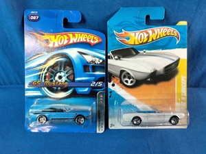 Two Hot Wheels die-cast toy car packages featuring a blue 65 Mustang on the left and a white 63 Mustang II Concept on the right