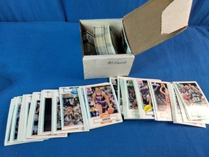 Vvintage 1990-91 Fleer Basketball trading cards, including a visible Magic Johnson card (#93), displayed with a cardboard storage box