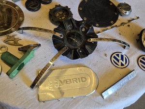 Lot of Automotive Emblems and Caps Featuring Brands such as Volkswagen, Volvo, and Nissan
