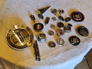 Lot of automotive emblems including Lincoln, Buick, Cadillac, and Mercury