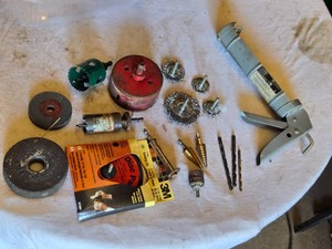Assorted Tools including Caulking Gun, Hole Saws, Drill Bits, and Grinding Discs