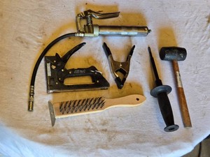 Assorted Hand Tools Including Staple Gun, Rubber Mallet, and Grease Gun