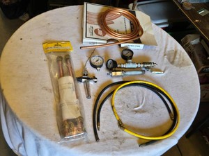 Miscellaneous Industrial and Plumbing Tools including Copper Coil, Pressure Gauges, and Hoses