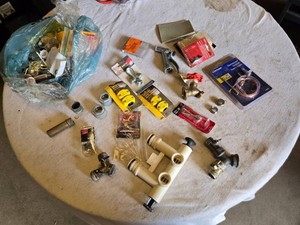 Assorted Plumbing and Hardware Items including Faucet Valves, Hose Menders, and Assorted Fasteners