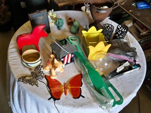 Collection of home decor and garden items such as figurines, a planter, candle holders, a butterfly ornament