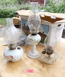 Two milk glass and one clear glass oil lamps