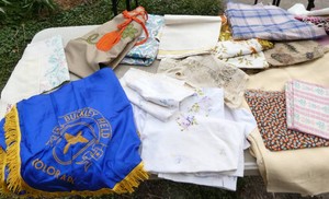 Tote full of tablecloths, apron, pillow cases, fabric pieces, doilies