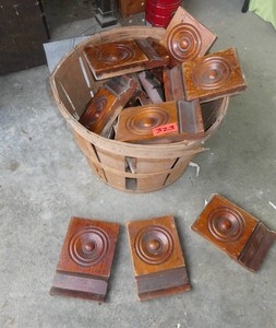 Basket full of antique wooden bullseye plinth blocks or rosette trim blocks featuring a classic circular bullseye center