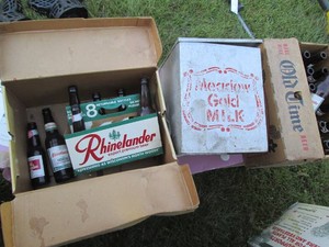 Vintage metal milk cooler and (2) cardboard beer cases with misc glass bottles