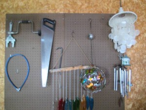 Variety of assorted styles and material Wind chimes plus misc hand tools shown