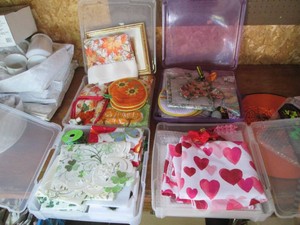 Misc Scrapbook style storage containers containing a variety of seasonal household items and decor