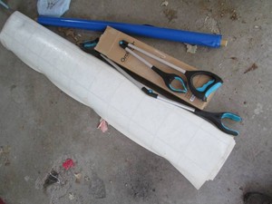 Rolls of unknown size linoleum and plastic covering plus (1) helping hand grab tools