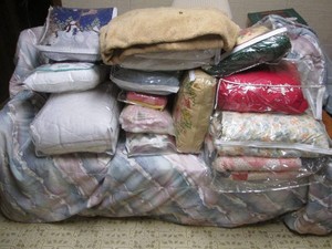 A large collection of comforters, blankets and womens sweaters