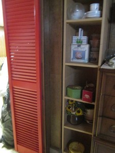 Tall wood space saver shelf with vintage ceramic ashtray, misc dishes and home decor