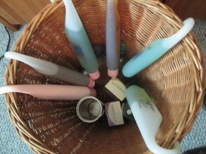 Wicker waste basket containing a variety of shower gels, soaps and other personal care supplies