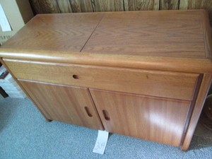 Wood Credenza style barware cabinet with slide-out top revealing another surface and power outlets